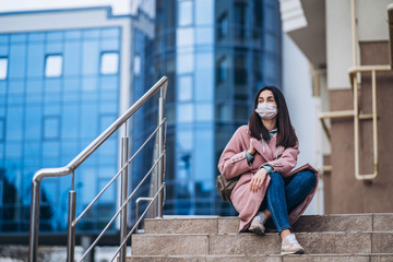 Fototapeta premium Female in medical protective mask outdoors in the empty city. Health protection and prevention of virus outbreak, coronavirus, COVID-19, epidemic and pandemic, quarantine concept