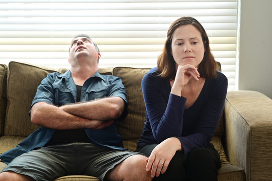 Sad adult couple forced to stay at home as the pandemic coronavirus (COVID-19) forces many people to stay at home because new government policies