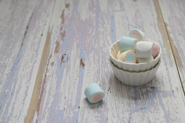 Color fruit marshmallows in the small bowl on the old pink table