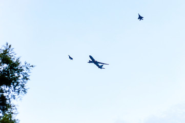 fighter jets escort a large airplane