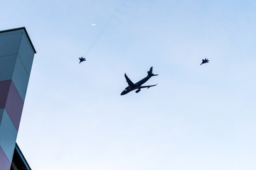 fighter jets escort a large airplane