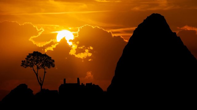 Machu Picchu: Ruins of Ancient Inca City, Time Lapse at Sunset with Red Clouds, Fiery Sky and Dark Silhouette of Mountains, Peru