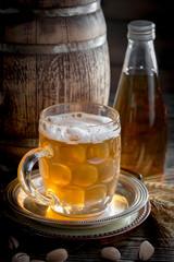 Light frothing beer in a glass, on an old background.