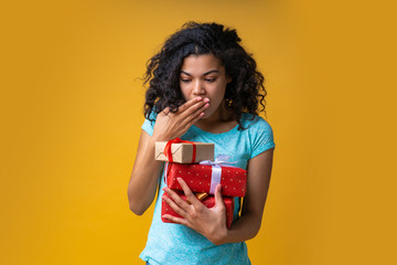 Attractive young african american woman with gift box in hands