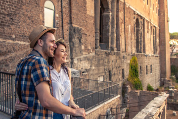 Fototapeta na wymiar Young couple tourist at Roman Forum at sunrise. Historical imperial Foro Romano in Rome, Italy from panoramic point of view.