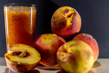 Glass of peach juice (Prunus persica L.) and fresh fruit