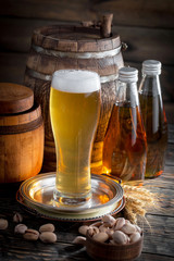 Light frothing beer in a glass, on an old background.