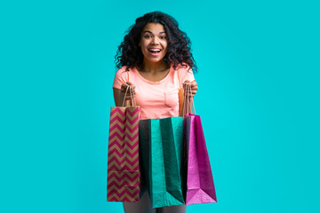 Attractive young dark skinned woman with a bunch of shopping bags