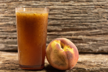 Glass of peach juice (Prunus persica L.) and fresh fruit