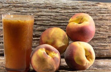 Glass of peach juice (Prunus persica L.) and fresh fruit