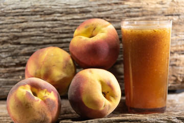 Glass of peach juice (Prunus persica L.) and fresh fruit
