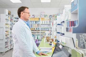 Naklejka na ściany i meble Pharmacist working in a drugstore