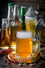 Light beer in a glass on a table in composition with accessories on an old background