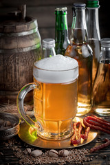 Light frothing beer in a glass, on an old background.