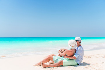 Young couple on white beach during summer vacation. Happy lovers enjoy their honeymoon