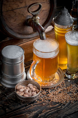 Light frothing beer in a glass, on an old background.