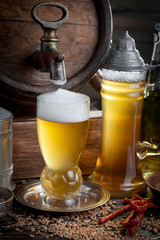 Light frothing beer in a glass, on an old background.