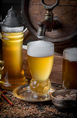 Light beer in a glass on a table in composition with accessories on an old background