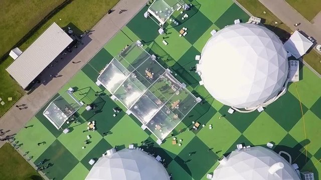 Aerial view of spherical tents with people gathering around them.