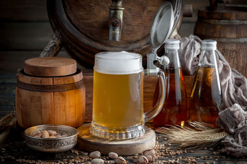 Light frothing beer in a glass, on an old background.