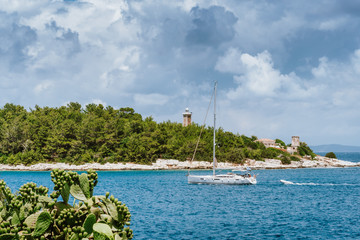 Summer holiday vacation. Kefalonia island, Greece. White sailing boat approaching port of Fiskardo