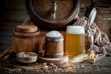 Light frothing beer in a glass, on an old background.