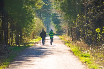 A mother and her son  do nordic walking on a forest path during the corona virus lockdown in germany, with families and single persons allowed to go out on strolls.