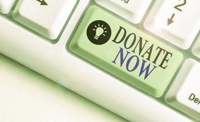 Writing note showing Donate Now. Business concept for to give something like money or goods to a...