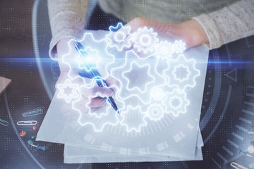 International business hologram over woman's hands taking notes background. Concept of success....