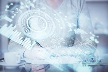 International business hologram over woman's hands taking notes background. Concept of success. Double exposure