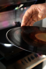 black vinyl music disc for the player in male hands, the concept of retro music, lifestyle