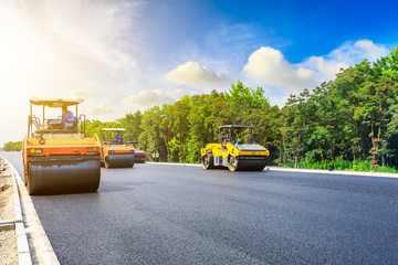 Obraz premium Construction site is laying new asphalt road pavement,road construction workers and road construction machinery scene.highway construction site landscape.