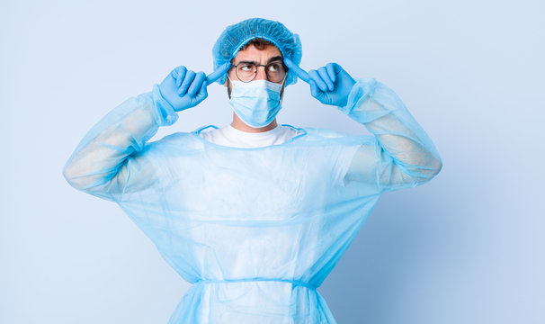 young man feeling confused or doubting, concentrating on an idea, thinking hard, looking to copy space on side. coronavirus concept - Powered by Adobe