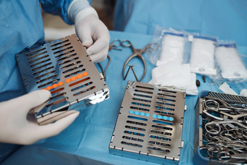 Surgeon prepering a set surgical instruments before surgery.