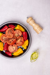 Big Black Plate with Vegetables Plate of Ripe Peppers and Tomatoes with Spices Ready to Grill Vegetadian Healthy Dinner Salt Oil Vertical