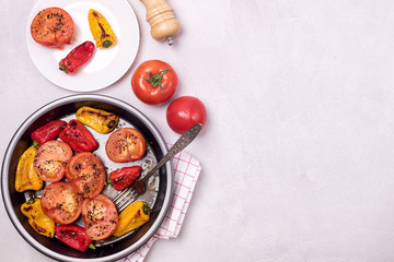 Big Black Plate and Small White Plate of Grilled Vegetables on Light Background Baked Tomatoes and Peppers Tasty Healthy Diet Dinner or Lunch Top View Salt Copy Space