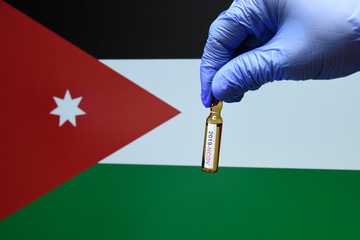 Corona virus or Covid-19 in Jordan , sample blood tube in hand with Jordan flag on background