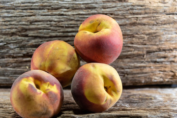 Peach fruits (Prunus persica) in natura on a woody background