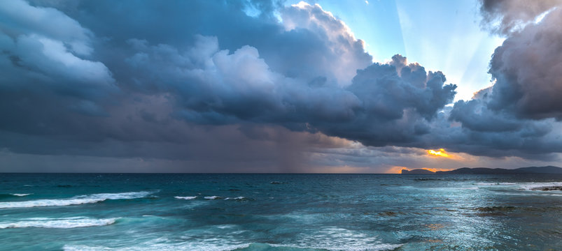Dark clouds over Capo Caccia at sunset