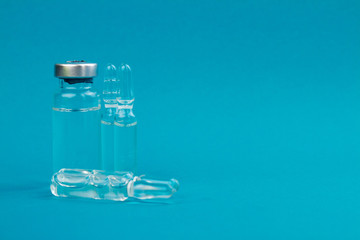 Small ampoules with medicine. Isolated on blue background with copy space.