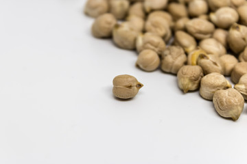 One dry chickpea (Cicer arietinum) in front closeup with a heap on the background, chick pea seeds,kabuli chickpea variety - Image