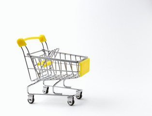 An empty shopping cart with a yellow handle on a white background. Space for text. Side view