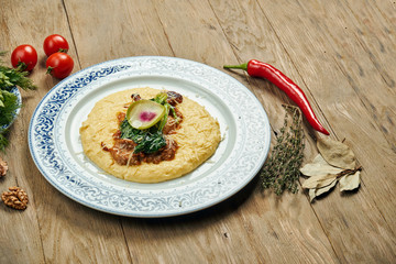 Juicy and unusual Israeli chicken steak (Pargiyot) with a side dish of polenta, corn porridge. Grilled chicken. Wooden background