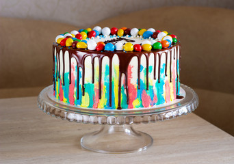 children's birthday cake with bright strokes of cream and chocolate on the table