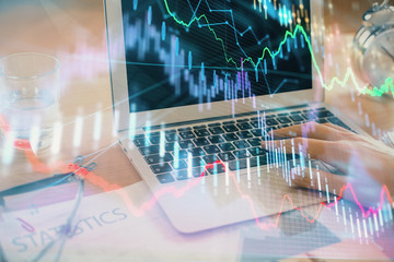 Multi exposure of market chart with man working on computer on background. Concept of financial analysis.