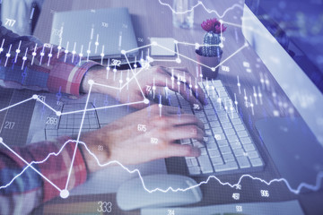 Obraz na płótnie Canvas Double exposure of stock market chart with man working on computer on background. Concept of financial analysis.