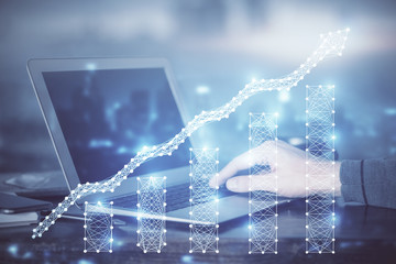 Double exposure of stock market graph with man working on laptop on background. Concept of...