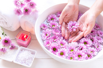Obraz na płótnie Canvas Spa treatment and massage product for female feet and manicure nails spa with pink flower. Woman happy and relax with spa massage Thai. Healthy and Beauty Concept.