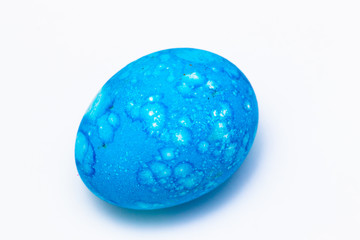 Easter colored egg of turquoise or blue color on a white background.
