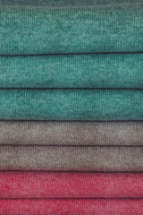 Arrière plan pull over en laine empilés aux couleurs vives